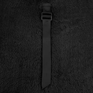 Close-up detail of the adjustment strap and buckle on black polar fleece jacket.