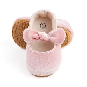 Close-up of pink velvet baby princess shoes with soft bow and anti-slip sole