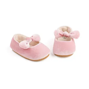 Vista detallada de zapatos de princesa para bebé en terciopelo rosa con lazo decorativo