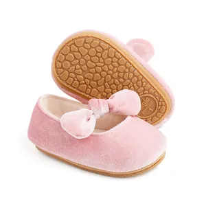 Detail shot of pink velvet baby princess shoes with bow and anti-slip sole pattern.