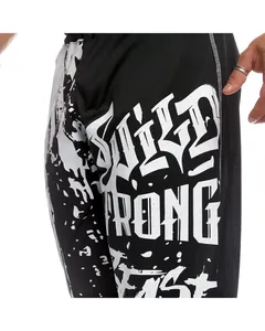 Close-up of WILD STRONG FAST graffiti print on black men's quick-dry sports pants
