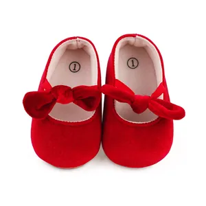 Vista detallada de zapatos de princesa para bebé en terciopelo rojo con lazos suaves