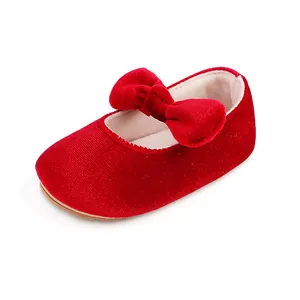 Soft red velvet baby girl dress shoe featuring a large bow and anti-slip rubber sole