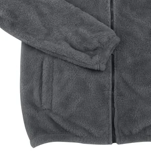 Gros plan sur la texture d'une veste en polaire grise avec fermeture éclair et poche