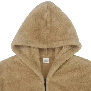 Detailopname van een pluizige bruine jas met capuchon en zachte sherpa-texturen