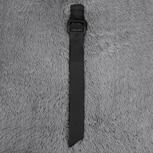 Macro view of a durable black nylon adjustment strap with plastic buckle for jackets