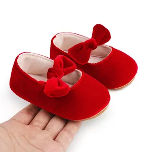 Detalle de cerca de zapatos de bebé en terciopelo rojo con un lazo decorativo de felpa suave