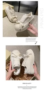 Primo piano dei lacci larghi e suole spesse di sneakers in pelle color crema.