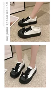 Vista dettagliata di scarpe biscotto in pelle bianca e nera con plateau indossate da una modella.