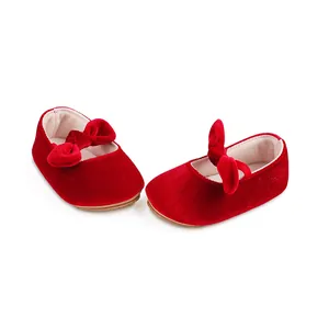 Una vista detallada de zapatos de bebé en terciopelo rojo con lazos elegantes decorativos