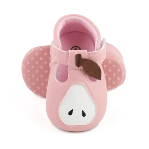 Vue détaillée de chaussures de marche bébé roses avec motif poire et semelle antidérapante