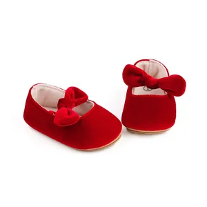 Detail view of red velvet baby princess shoes featuring a soft bow embellishment