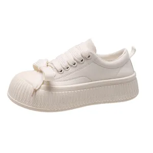 Vista laterale delle sneakers platform in pelle bianca da donna con suole spesse.