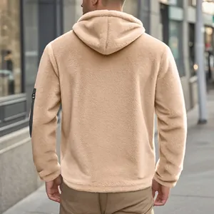 Detailed back view of a cozy beige men's hooded fleece jacket in an urban street setting
