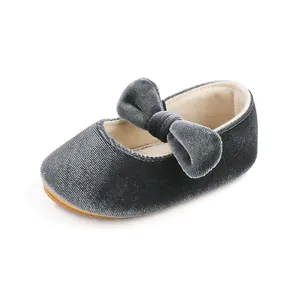 Close-up detail of a elegant grey velvet baby girl princess shoe with a large bow