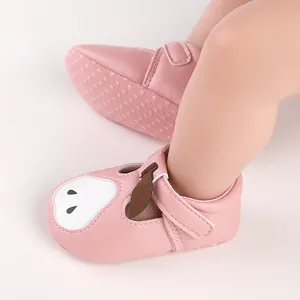 Gros plan de chaussures de marche pour bébé roses avec visage de dessin animé