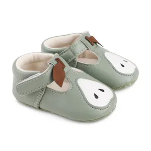 Détail de chaussures de marche vertes pour bébé avec motif de poire et velcro