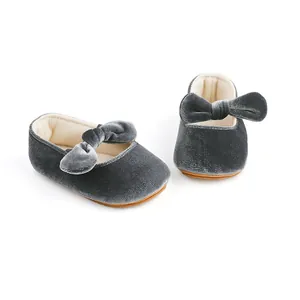 Vista detallada de los zapatos de princesa para bebé en terciopelo gris con un lazo muy elegante.
