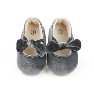 Close-up detail of grey velvet baby princess shoes with a decorative bow for infants