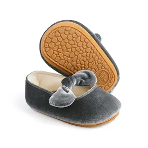 Detalle de zapatos de princesa de terciopelo gris para bebé con suela antideslizante