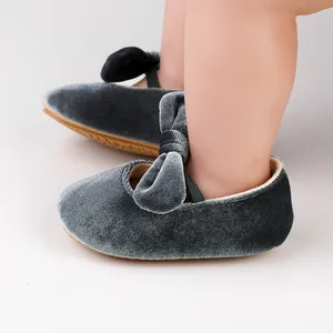 Vista lateral detallada de zapatos de princesa para bebé en terciopelo gris suave