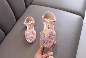 Detail of pink glittery girls' princess shoes with rhinestone bunny and pearl strap.