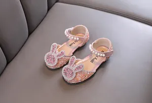 Detail shot of pink rhinestone princess shoes with pearl straps and bunny ornament