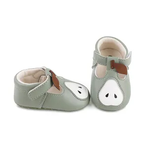Vue rapprochée de chaussures de marche pour bébé vert sauge avec un joli motif de poire.