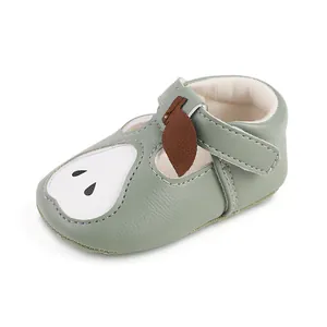 Détail d'une chaussure pour bébé vert clair avec motif poire mignon et bride velcro