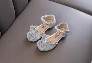 Detailed view of silver girls' dress shoes with rhinestone bunny and pearl strap