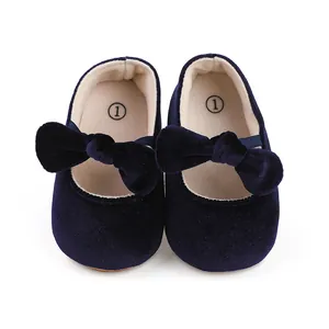 Close-up of navy blue velvet baby girl dress shoes with large bow details