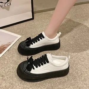 Sneakers con zeppa bianche e nere da donna con suola spessa e decorativi lacci a fiocco
