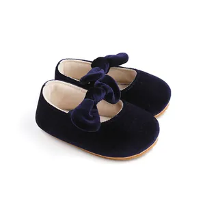 Vista detallada de zapatos de bebé de terciopelo azul marino con un lazo suave