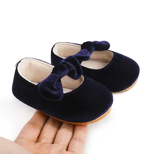 Primer plano de zapatos de princesa para bebé en terciopelo azul marino con lazo