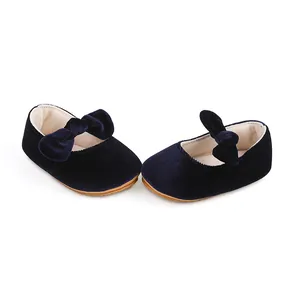 Vista detallada de zapatos de princesa para bebé en terciopelo azul con lazo elegante.