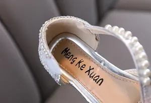 Detailed view of silver girl's princess shoes with shiny rhinestones and pearls