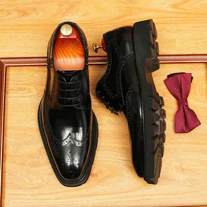 Chaussures Richelieu noires pour hommes avec semelles épaisses sur fond bois
