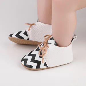 Newborn baby soft sole walking shoes with black chevron pattern and tan lace-up detail