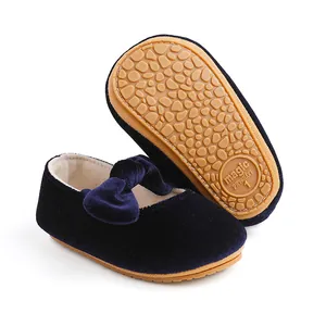 Close-up detail of navy blue velvet baby shoe with bow and non-slip rubber sole