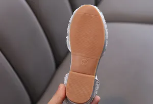 Detailed view of the non-slip rubber sole on a silver rhinestone girl's princess shoe