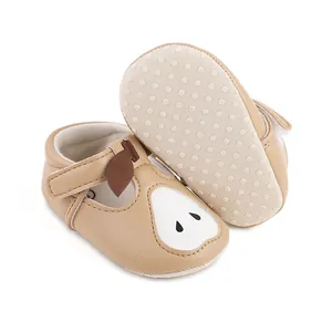 Détail de chaussures de marche pour bébé avec semelle antidérapante et motif poire