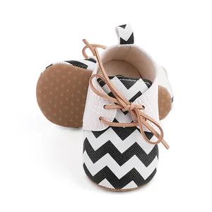 Close-up of baby walking shoes with black and white zigzag pattern and soft soles