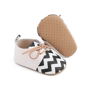 Detail view of baby walking shoes with black and white chevron pattern and anti-slip sole