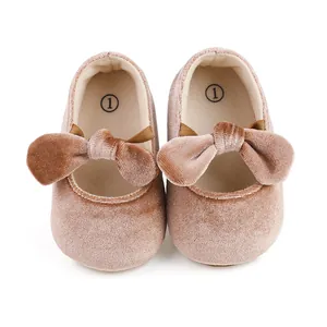 Macro view of pink velvet baby princess shoes featuring a soft bow detail for infants