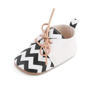 Classic black and white chevron pattern baby walker shoes featuring elegant tan bow laces