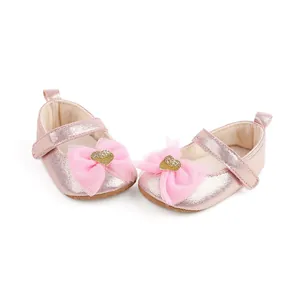Detail view of pink baby princess shoes with tulle bows and gold heart sequins.