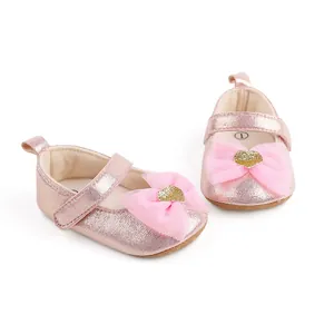 Detail view of pink glitter baby princess shoes with mesh bow and gold heart