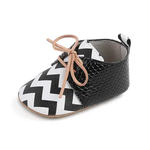 Detail view of infant baby walker shoe with chevron pattern and snakeskin texture.