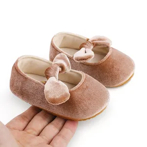 Detalle de los zapatitos tipo Mary Jane para bebé en terciopelo rosa con lazo decorativo