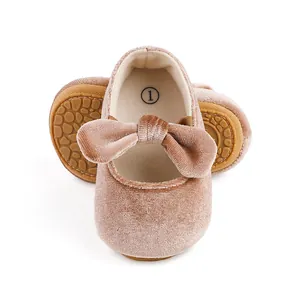 Close-up of a pink velvet baby girl dress shoe featuring a soft bow and non-slip rubber sole